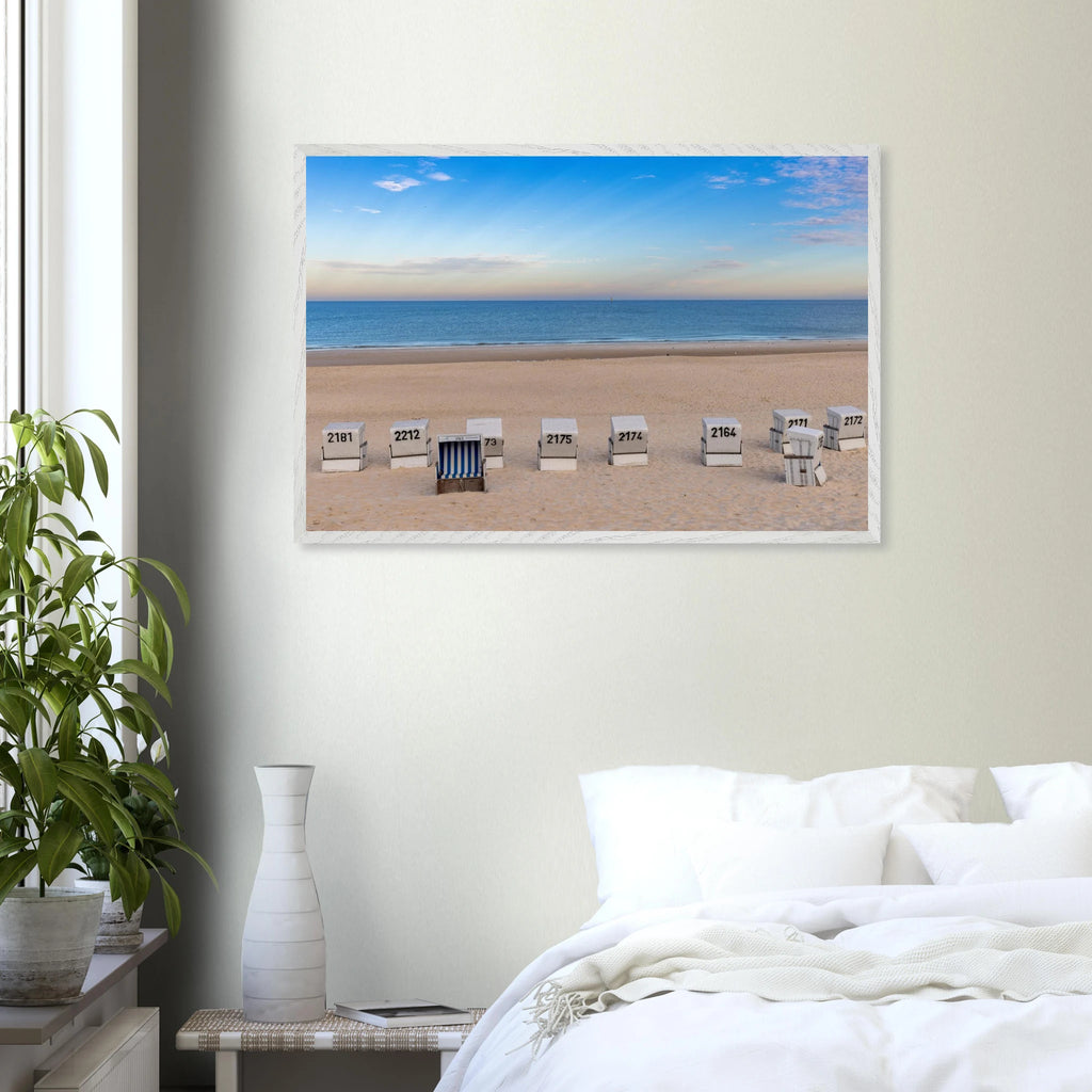 Horizontaler Kunstdruck mit Blick auf den Strand von Westerland auf Sylt: weiße Strandkörbe im hellen Sand, dahinter die ruhige blaue Nordsee und ein weiter sommerlicher Himmel mit feinen Wolken.
