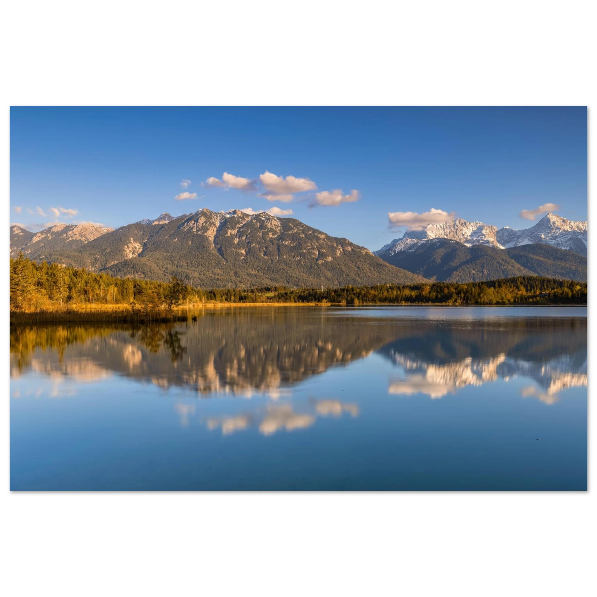 Stimmungsvolle Aufnahme des Barmsees in Oberbayern mit ruhiger Spiegelung der Berge im klaren Wasser, sanftem Abendlicht und weiter blauer Himmelkulisse.