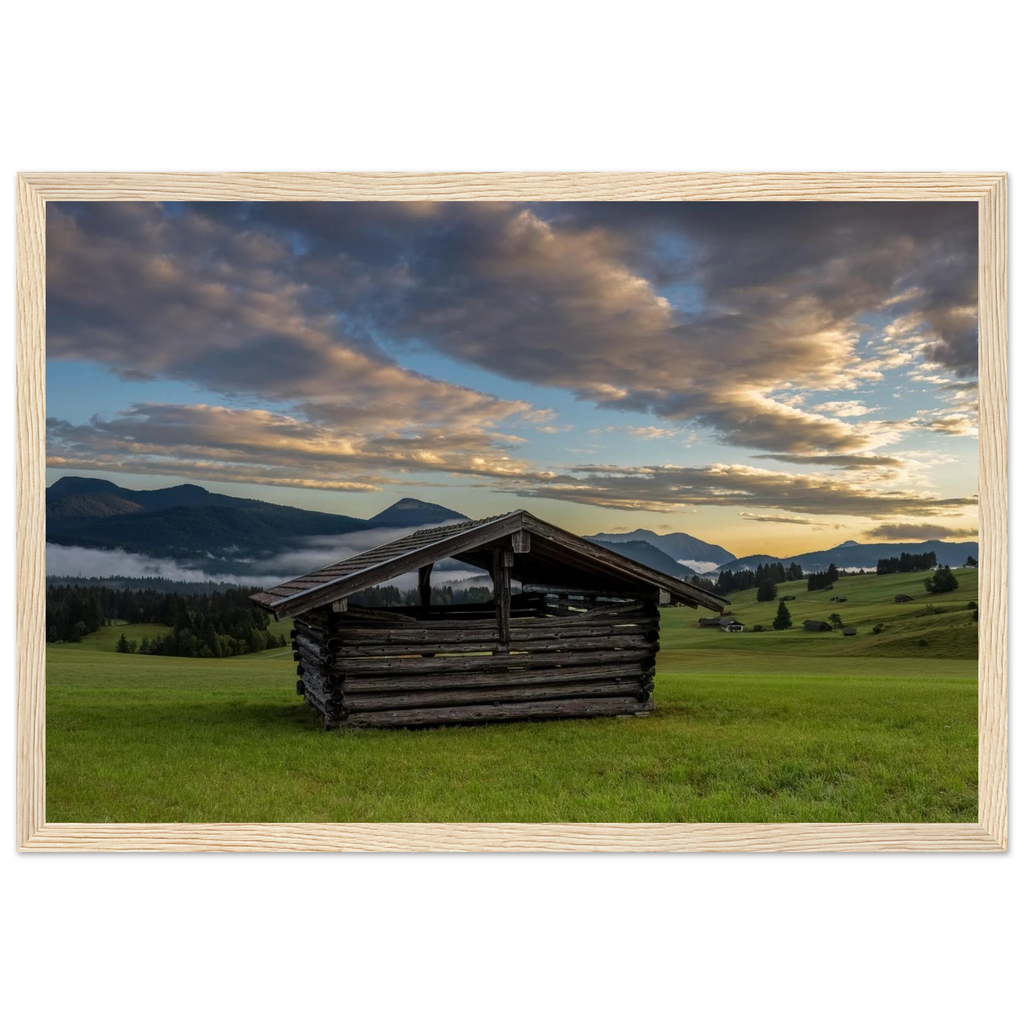 Morgens in den Buckelwiesen – alter Heustadel zwischen grünen Wiesen, Nebel und Bergen unter dramatischen Wolken im warmen Morgenlicht.
