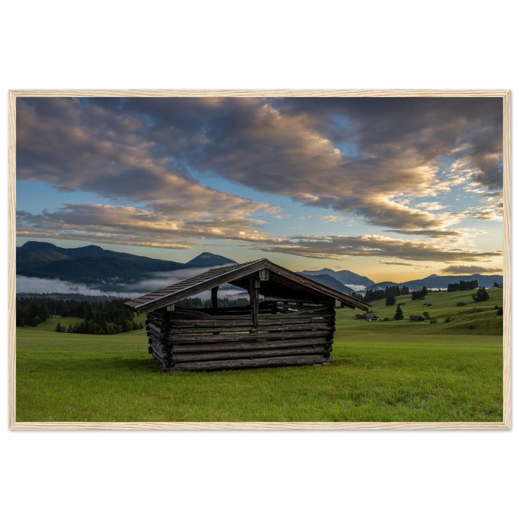 Morgens in den Buckelwiesen – alter Heustadel zwischen grünen Wiesen, Nebel und Bergen unter dramatischen Wolken im warmen Morgenlicht.
