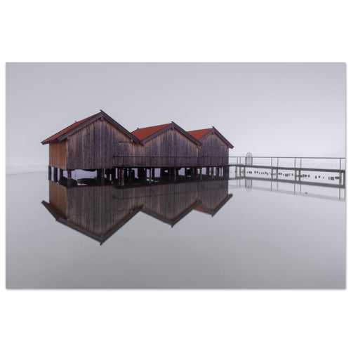 Minimalistische Naturfotografie vom Kochelsee in Oberbayern mit Bootshäusern, feiner Spiegelung und ruhiger Nebelstimmung.