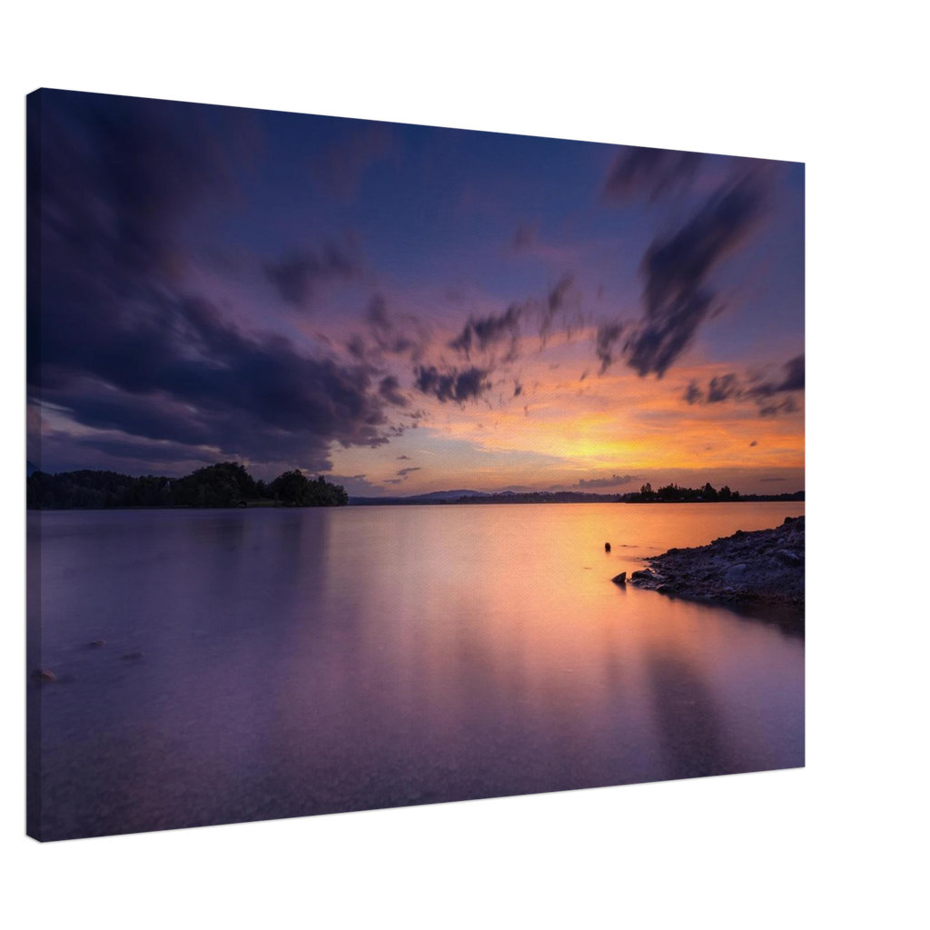 „Leinwandbild eines spektakulären Sonnenuntergangs am Staffelsee in Seehausen, Oberbayern. Farbenprächtiges Wolkenspiel in Gold-, Orange- und Violetttönen über dem ruhigen See an einem warmen Sommerabend mit stimmungsvollen Spiegelungen im Wasser.“