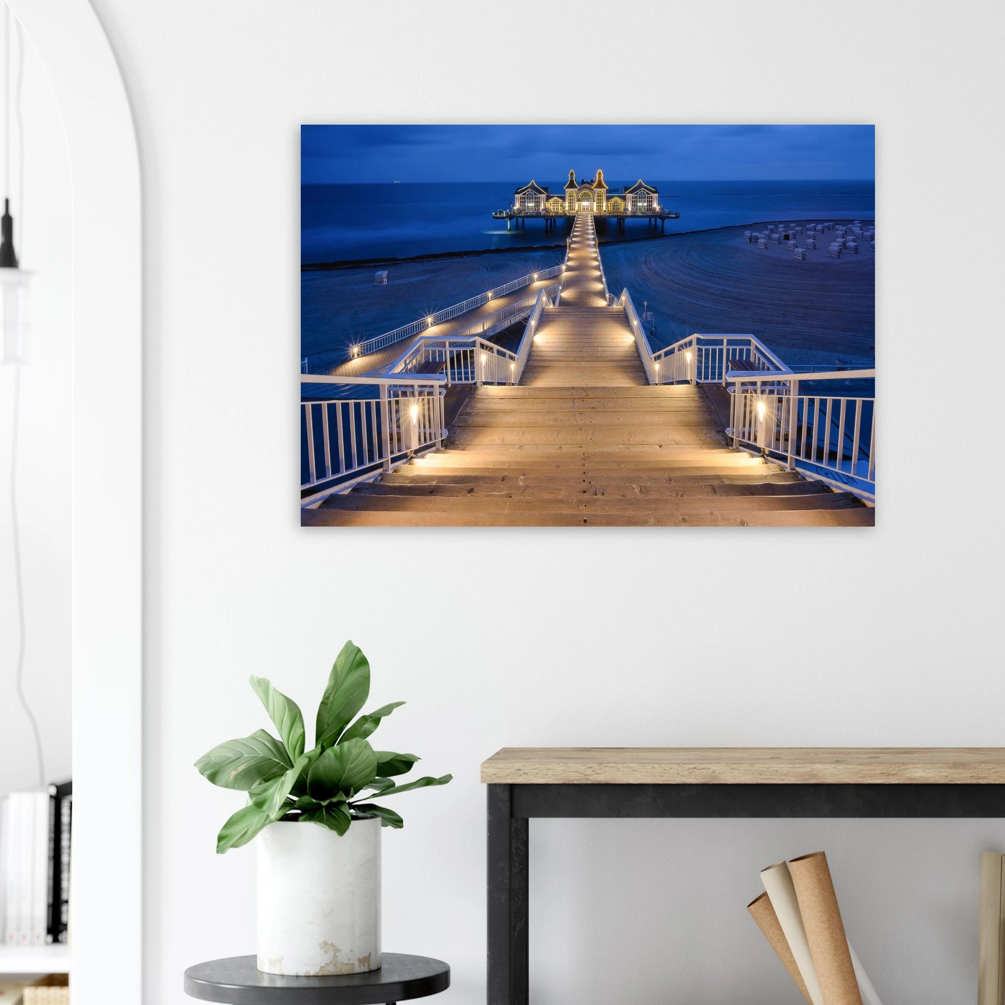 Seebrücke Sellin auf Rügen in der Blauen Stunde am Morgen. Der beleuchtete Holzsteg führt über den ruhigen Strand zur historischen Seebrücke und schafft eine stimmungsvolle Kulisse an der Ostsee.