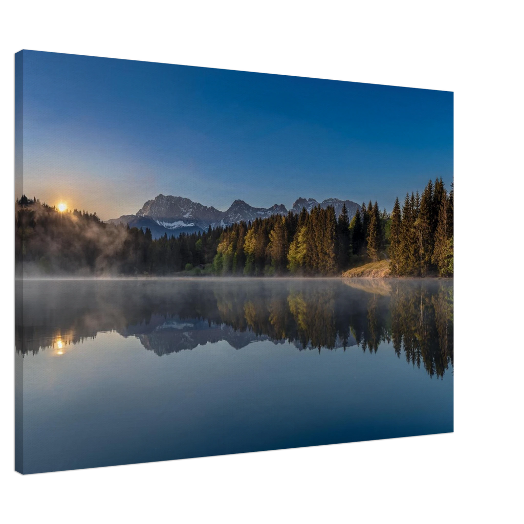 „Geroldsee bei Sonnenaufgang mit sanften Nebelschleiern über dem Wasser, klarer Spiegelung von Wald und Bergen im ruhigen See, warmes Morgenlicht auf den Bäumen und tiefblauer Himmel über der Alpenlandschaft in Bayern.“ Leinwand