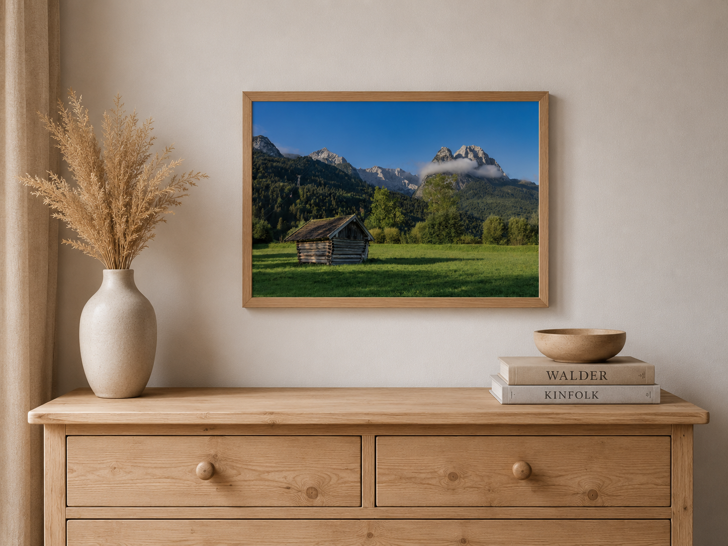 Gerahmtes Landschaftsposter im Format 30x45 mit hellem Holzrahmen. Das Motiv zeigt eine kleine Holzhütte auf einer grünen Wiese vor einer imposanten Bergkulisse in Garmisch-Partenkirchen, unter tiefblauem Himmel und sanften Wolken – eine natürliche Szene voller Ruhe, Weite und alpiner Atmosphäre.