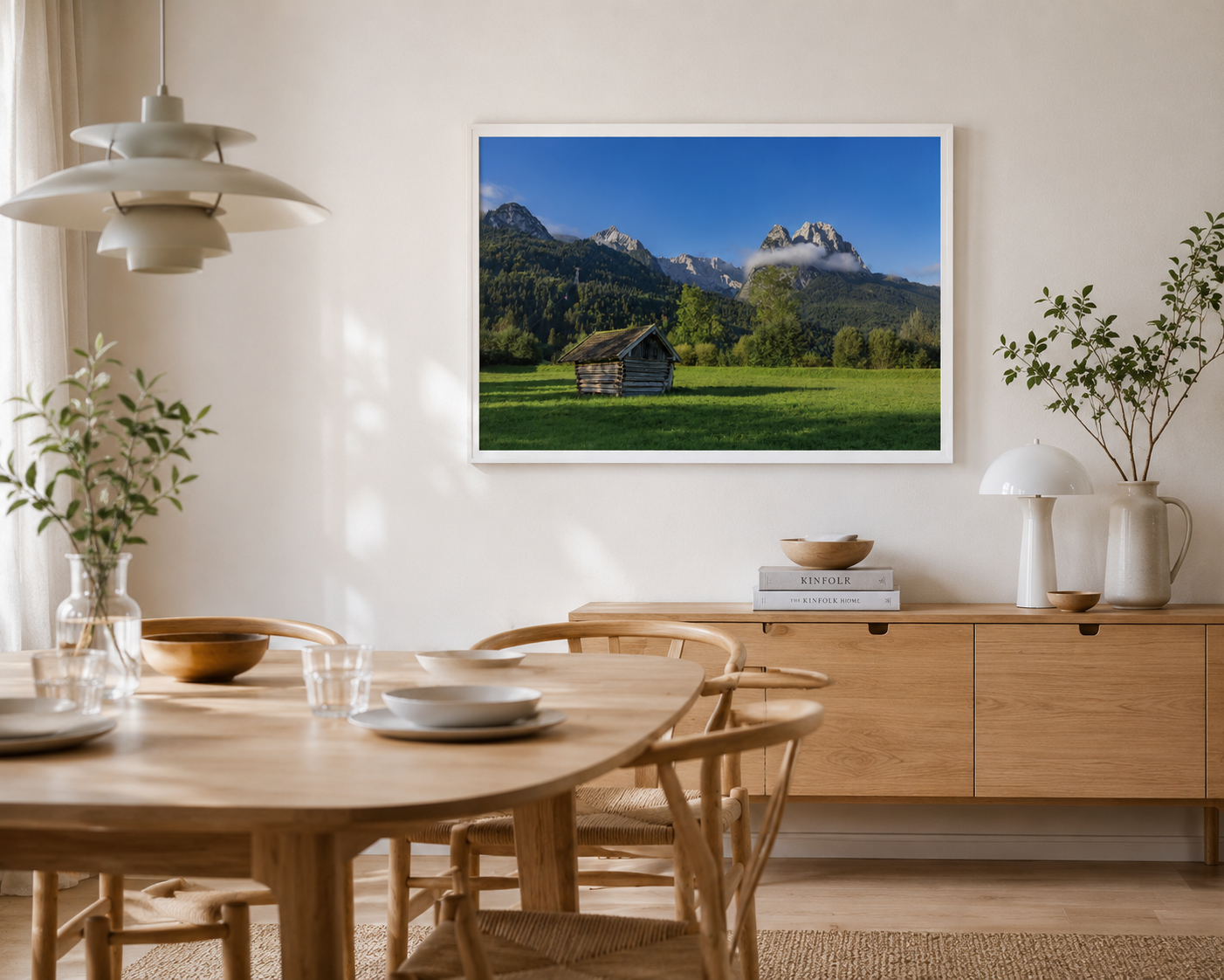 Gerahmtes Landschaftsposter im Format 60x90 cm mit weissem Holzrahmen. Das Motiv zeigt eine kleine Holzhütte auf einer grünen Wiese vor einer imposanten Bergkulisse in Garmisch-Partenkirchen, unter tiefblauem Himmel und sanften Wolken – eine natürliche Szene voller Ruhe, Weite und alpiner Atmosphäre. Esszimmer.