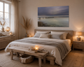 Ruhiges Schlafzimmer im skandinavischen Naturstil mit hellem Holzboden und Möbeln aus naturbelassenem Holz. Über dem Bett hängt ein ungerahmtes Ammersee-Poster im Format 60 × 90 cm. Das Motiv zeigt einen stillen See mit verwittertem Steg, klarem Wasser und einem weiten, wolkenverhangenen Himmel in sanften Grau-, Beige- und Blautönen. Helle Bettwäsche, warme Beleuchtung, natürliche Materialien und dezente maritime Dekoration schaffen eine entspannte Atmosphäre voller Ruhe, Geborgenheit und zeitloser Eleganz.