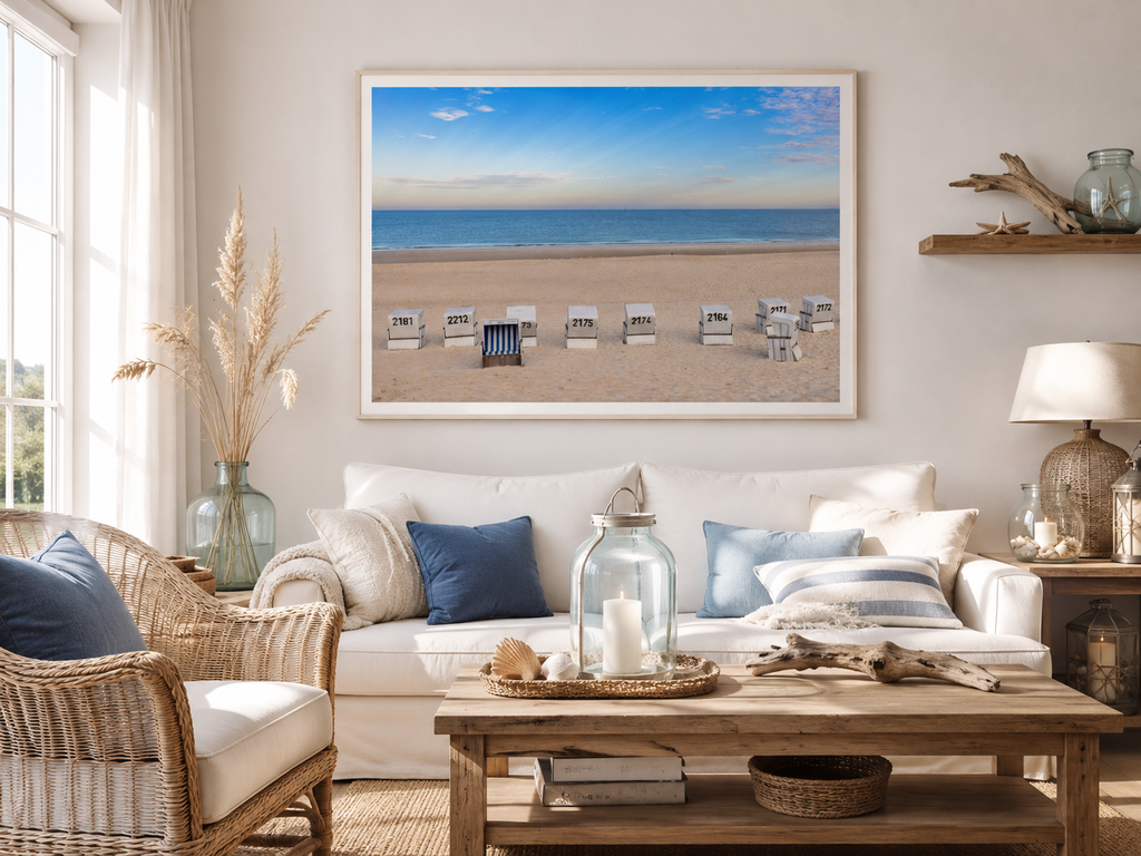 Helles Wohnzimmer im Sylt-Stil mit maritimer Dekoration aus Naturholz, Rattan, Glas und blauen Akzenten. An der Wand hängt ein horizontal gerahmtes Poster mit weißem Holzrahmen, das den Strand von Westerland auf Sylt mit Strandkörben, Nordsee und weitem blauem Himmel zeigt. Das Wohnraum-Mockup wurde mit KI erstellt, die verwendete Fotografie stammt von mir.