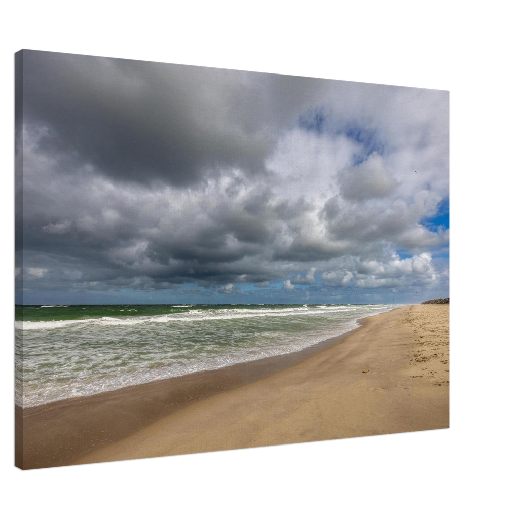 Alttext:
Weite Strandlandschaft in Westerland auf Sylt mit kräftiger Nordseebrandung, aufgewühltem grünblauem Meer, feinem Sandstrand und eindrucksvollen dunklen Wolken unter aufbrechendem blauem Himmel.
