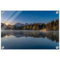 Ein stiller Morgen am Geroldsee in Oberbayern. Feine Nebelschleier ziehen sanft über das ruhige Wasser, während sich die umliegenden Wälder und die Bergwelt nahezu vollkommen im See spiegeln. Das erste warme Licht des Tages berührt die Bäume und schenkt der Landschaft eine besondere Ruhe und Tiefe.

Acryl Bild