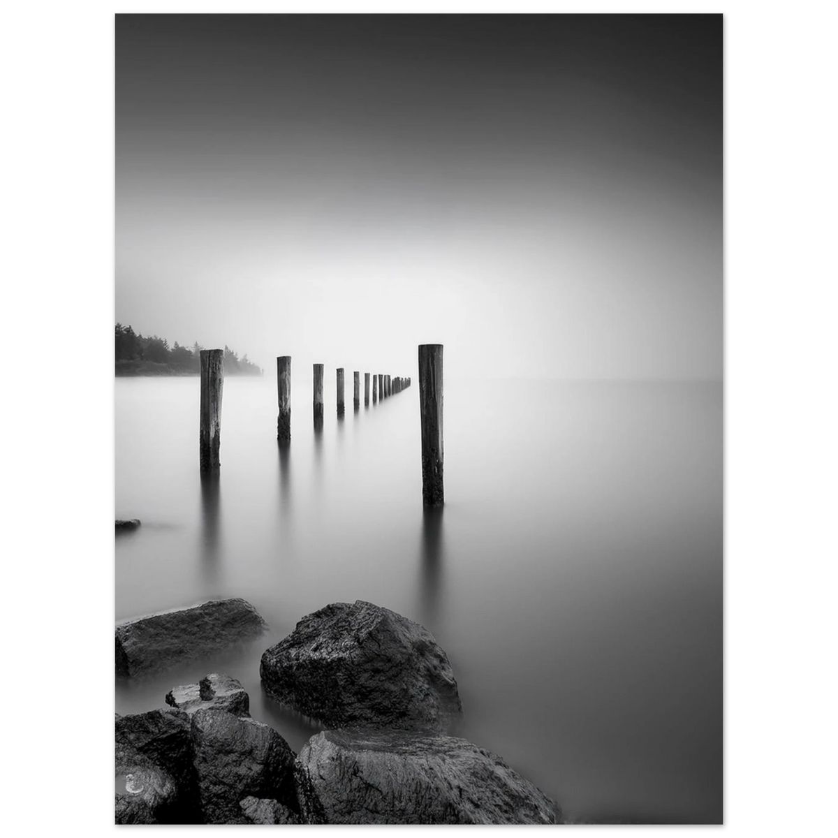 `Schwarzweiß Fine Art Poster "Stille am See im Nebel" – verwitterte Holzpfähle im Seenebel, Premium Mattepapier, Christina Bauer Photos` Stimmungsvolle Schwarz-Weiß-Fotografie einer nebligen Seenlandschaft mit einer langen Reihe alter Holzpfähle, die im ruhigen Wasser verschwinden. Eine Langzeitbelichtung verleiht der Wasseroberfläche eine samtweiche Struktur. Dunkle Felsen im Vordergrund und sanfte Spiegelungen unterstreichen die minimalistische, geheimnisvolle Atmosphäre.