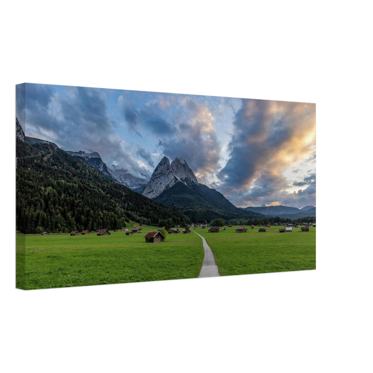 des  Werdenfelser Land mit Abendstimmung und so an scheena Bergblick! Landschaftsfotografie aus Garmisch-Partenkirchen mit Blick auf das imposante Wettersteingebirge. Ein schmaler Weg führt durch weitläufige grüne Wiesen mit traditionellen Heustadeln. Dramatische Wolken und sanftes Abendlicht tauchen die bayerische Alpenlandschaft in eine stimmungsvolle Atmosphäre.