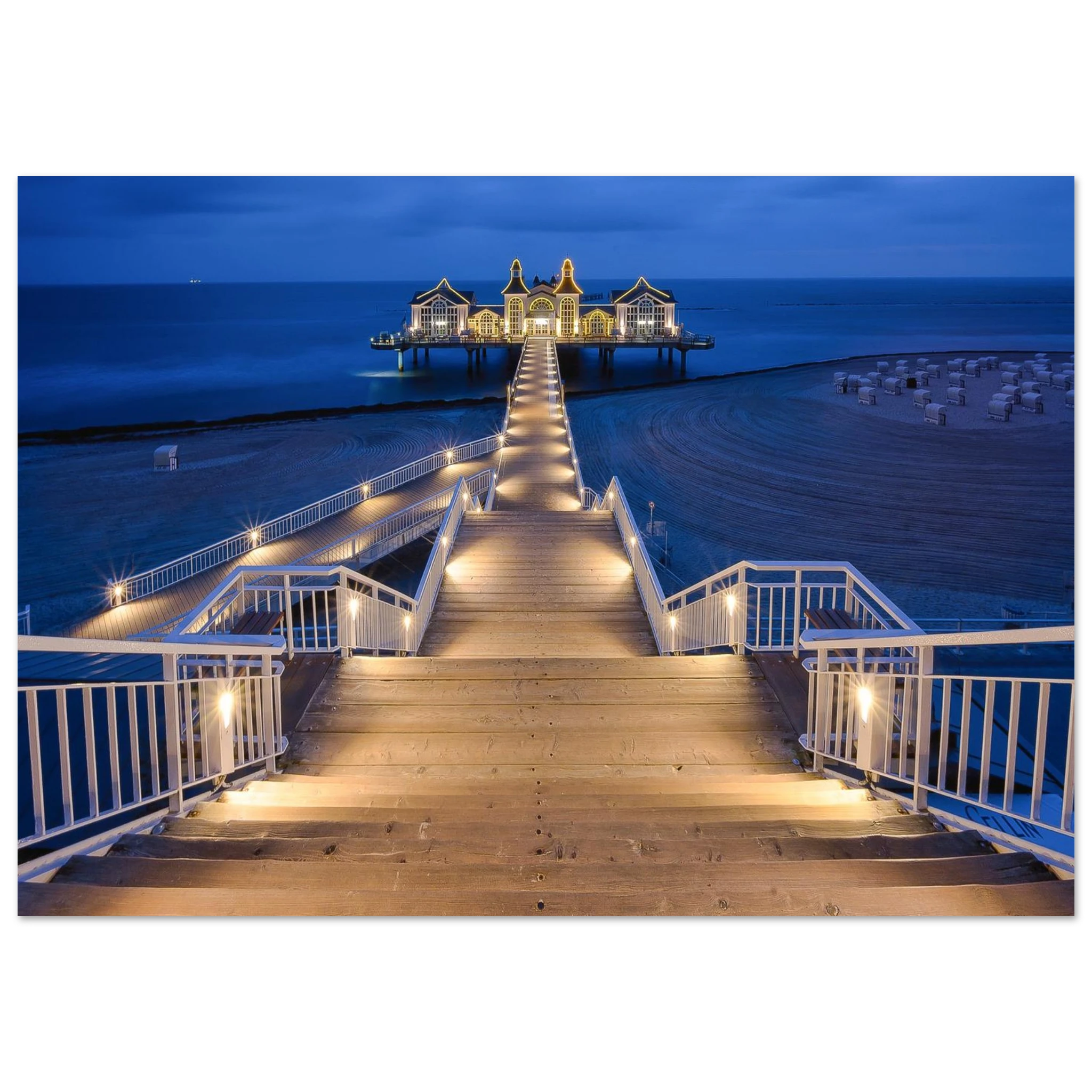 Seebrücke Sellin auf Rügen in der Blauen Stunde am Morgen. Der beleuchtete Holzsteg führt über den ruhigen Strand zur historischen Seebrücke und schafft eine stimmungsvolle Kulisse an der Ostsee.