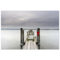Alter Holzsteg am Ammersee mit einem leuchtend roten Schal, der an einem Pfosten befestigt ist. Die ruhige Langzeitbelichtung, das glatte Wasser und der sanft bewölkte Himmel schaffen eine stille, minimalistische Atmosphäre in Oberbayern.