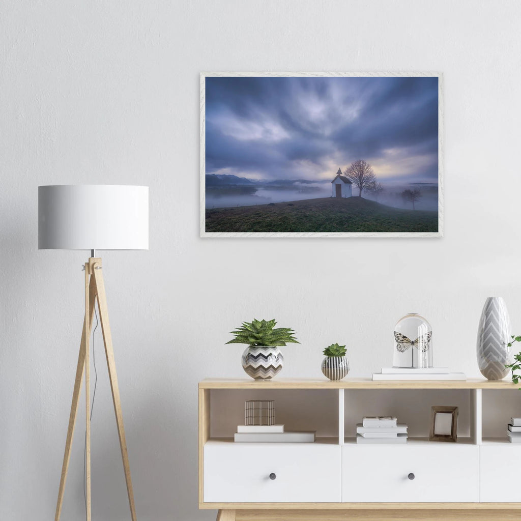 Hoch über der Landschaft bei Aidling im Blauen Land steht die kleine Mesnerhauskapelle – still, schlicht und eingebettet in einen Morgen, der kaum leiser sein könnte. Nebelschleier ziehen durch die Landschaft, während sich das erste Licht vorsichtig seinen Weg durch Wolken und Himmel bahnt. Die Weite öffnet den Blick, die Zeit scheint für einen Augenblick langsamer zu werden.

Die besondere Stimmung dieses Moments lebt vom Zusammenspiel aus weichem Licht, ziehenden Wolken und den sanften Konturen des Landes