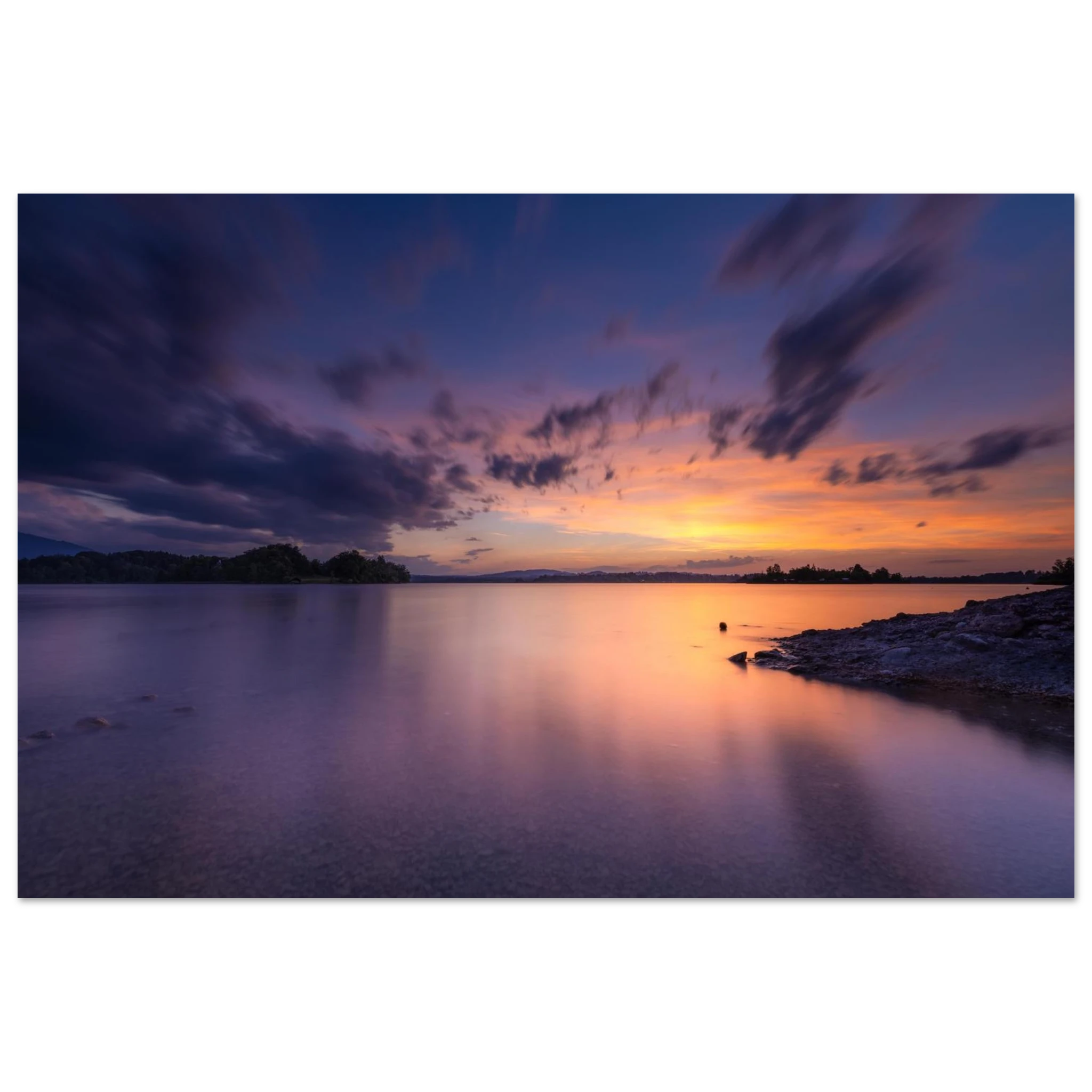 Spektakulärer Sonnenuntergang am Staffelsee in Seehausen, Oberbayern. Farbenprächtiges Wolkenspiel über dem ruhigen See an einem warmen Sommerabend mit sanften Spiegelungen im Wasser und meditativer Atmosphäre.