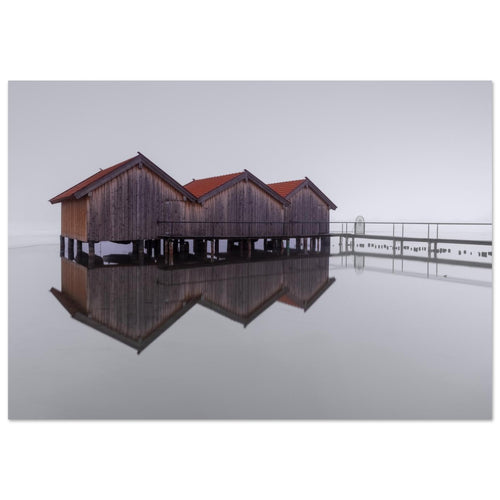 Minimalistische Naturfotografie vom Kochelsee in Oberbayern mit Bootshäusern, feiner Spiegelung und ruhiger Nebelstimmung.