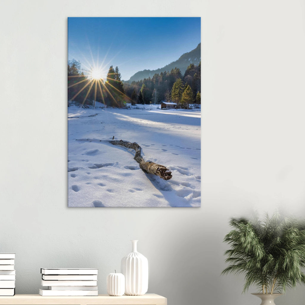 Winterliches Leinwandbild aus Garmisch-Partenkirchen mit strahlender Sonne über verschneiter Landschaft, vereistem Weiher, kleiner Holzhütte, Wald und Bergen im Hintergrund.