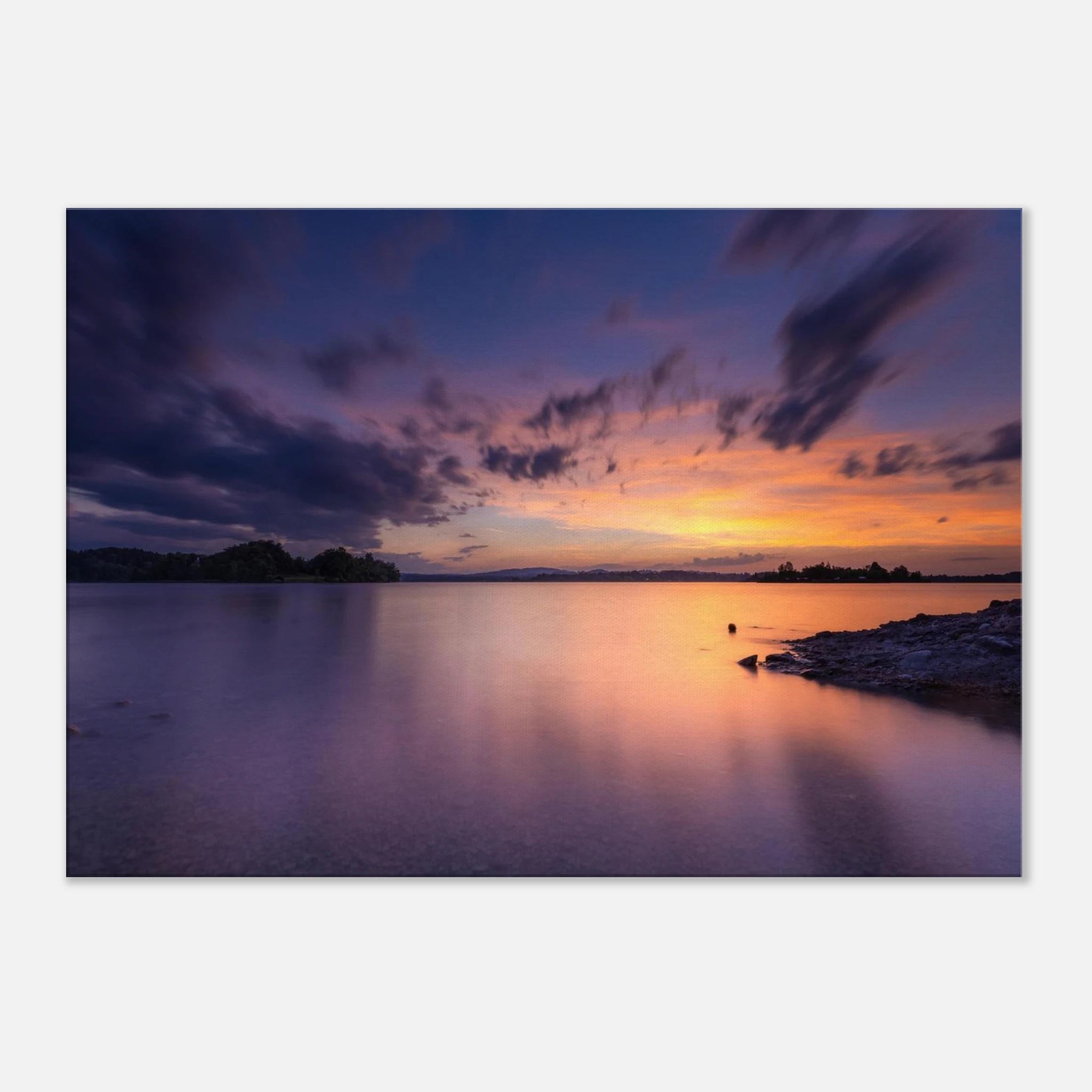 „Leinwandbild eines spektakulären Sonnenuntergangs am Staffelsee in Seehausen, Oberbayern. Farbenprächtiges Wolkenspiel in Gold-, Orange- und Violetttönen über dem ruhigen See an einem warmen Sommerabend mit stimmungsvollen Spiegelungen im Wasser.“